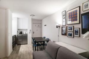 Una sala de estar con una mesa y una cocina. en Résidence La Petite Ourse - maeva Home - Studio 3 Personnes - Sélection MAE-4901, en Arâches-la-Frasse