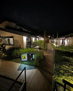 Ein Haus mit einem Schild, das nachts sagt: in der Unterkunft Pousada Terrazzo Bonjardim in Campos do Jordão