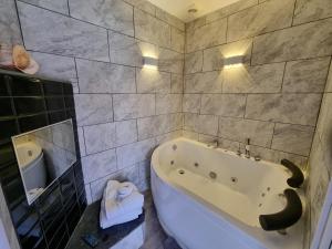 W łazience znajduje się wanna i umywalka. w obiekcie TIFFY'S PLACE Adult Guest House w Blackpool
