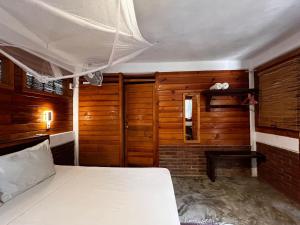 um quarto com uma cama e paredes de madeira em Casa Gaviota em Mazunte