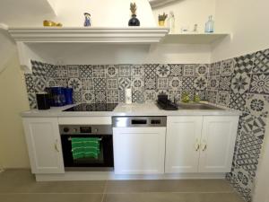 uma cozinha com armários brancos e um fogão com forno em Maison de Charme Classée 3 étoiles - Calme, Jardin, Salle de Sport, Piscine em Marselha