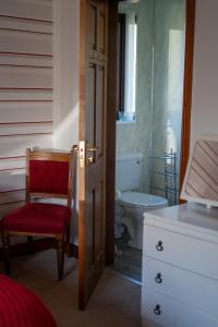 a bathroom with a toilet and a red chair at Glen Lodge in Ballymoney