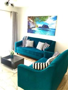 una sala de estar con un sofá azul y una pintura en Quiet Nest Homes, en Tatu City