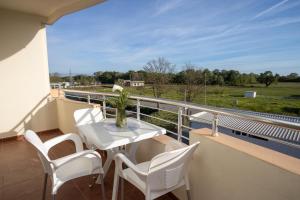 a balcony with a table and chairs and a view of a field at Villa Elezi in Ulcinj