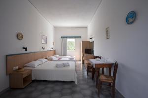 a bedroom with two beds and a table and chairs at Budget studios 50m from the beach and Perissa center in Perissa