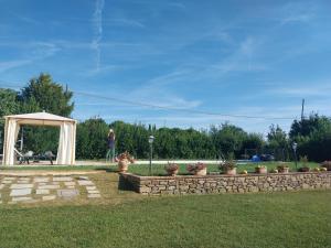 a woman walking through a park with a stone wall at La casa di Tommy in Cortona