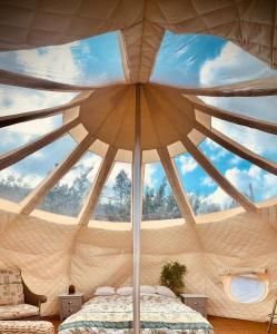 a room with a large ceiling with a bed in it at Forest Glamping Retreat in Blakeney