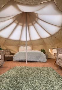 a bedroom in a tent with a bed in it at Forest Glamping Retreat in Blakeney