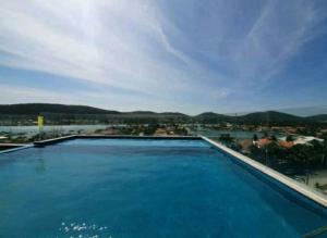 une grande piscine avec vue sur une ville dans l'établissement Flat 313 na melhor localização de Cabo Frio, à Cabo Frio