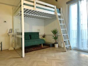 a bedroom with a bunk bed and a green couch at Loft Biagio50 in Centro in Ferrara