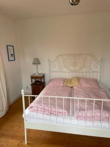 um quarto com uma cama branca e lençóis cor-de-rosa em Reiterhof em Lemgo