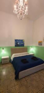 ein Schlafzimmer mit einem großen Bett und einem Kronleuchter in der Unterkunft B&B Maricentro in Taranto