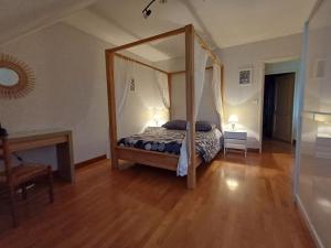 una camera con letto a baldacchino e pavimento in legno di LA CONFRERIE à MEURSAULT au CŒUR DE LA BOURGOGNE a Meursault Altre 25 foto