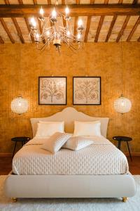 Schlafzimmer mit einem Bett und einem Kronleuchter in der Unterkunft Suite Casale Campovecchio in Grottaferrata