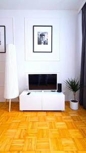 salon z telewizorem z płaskim ekranem na białej ścianie w obiekcie Praska Syrena w Warszawie