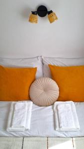 białe łóżko z pomarańczowymi poduszkami i poduszką w obiekcie Praska Syrena w Warszawie