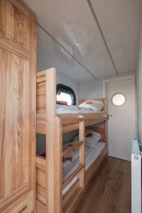 a bedroom with bunk beds in a tiny house at Hausboot Püntenel - stationär - Traumhafte Ferienwohnung AUF dem Wasser in Kinrooi