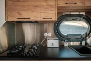 a kitchen with a sink and a toaster on a counter at Hausboot Püntenel - stationär - Traumhafte Ferienwohnung AUF dem Wasser in Kinrooi
