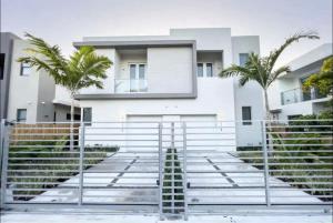 a white house with palm trees in front of it at Coconut Groove Green s VIlla in Miami