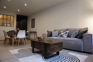 sala de estar con sofá y mesa en Hypercentre * Spacieux * Classy - Le Nid urbain en Pontarlier