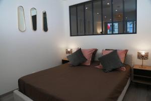 1 dormitorio con 1 cama con espejo en la pared en Hypercentre * Spacieux * Classy - Le Nid urbain en Pontarlier