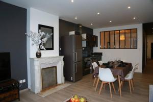 a kitchen and dining room with a table and a fireplace at Hypercentre * Spacieux * Classy - Le Nid urbain in Pontarlier