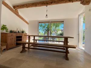 eine Holzbank in einem Zimmer mit einem großen Fenster in der Unterkunft Villa Quinson in Quinson