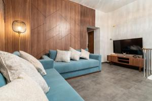 a living room with a blue couch and a television at luxueuse chambre de haut standing 1 in Brussels