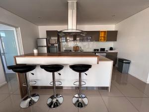 a kitchen with a bar with stools in it at Sky Cabins Apartments in Windhoek