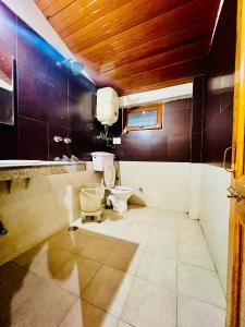 a bathroom with a toilet and a sink at Hotel Sliver Inn - Affordable Luxury Stay Near Mall Road in Manāli