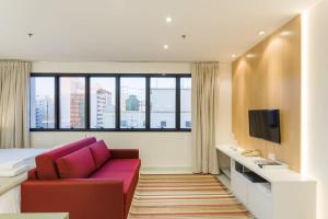 Camera d'albergo con divano e TV di BHomy Jardins Requinte e conforto CE1510 a San Paolo