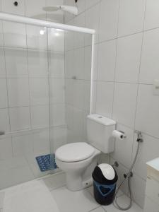a white bathroom with a toilet and a shower at Apartamento no Centro de Búzios in Búzios