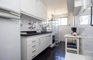 a kitchen with white cabinets and a sink at BHomy Jardins Vista incrível do MASP PT122 in Sao Paulo