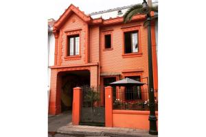 un edificio de ladrillo naranja con una puerta negra y una sombrilla en APARTHOTEL POVIDENCIA Santiago en Santiago