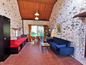 uma sala de estar com sofás vermelhos e azuis e uma parede de pedra em Nature, rivière et calme (A 25 min de Disneyland) em Jouarre