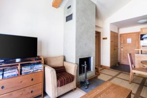 a living room with a tv and a fireplace at Résidence Les Terrasses d'Eos - maeva Home - Appartement 2 pièces 4 personnes - Prestige MAE-6034 in Arâches-la-Frasse