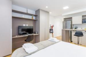 ein Schlafzimmer mit großem Bett und eine Küche in der Unterkunft BHomy Apm in São Paulo