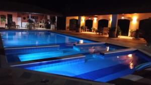 a large swimming pool at night with blue lighting at Sítio São Luiz: Experimente Autenticidade Rústica in Porangaba