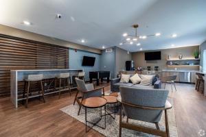 a living room with a couch and chairs and a bar at WaterWalk Wichita Downtown in Wichita