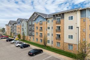 un complejo de apartamentos con coches aparcados en un aparcamiento en WaterWalk Wichita Downtown, en Wichita