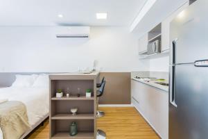 Kleines Apartment mit einem Bett und einem Kühlschrank. in der Unterkunft Studio redecorado no Bela Vista com Sacada e Lazer APM1205 in São Paulo