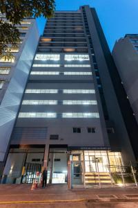 ein hohes Gebäude mit einer Drehtür davor in der Unterkunft Studio redecorado no Bela Vista com Sacada e Lazer APM1205 in São Paulo