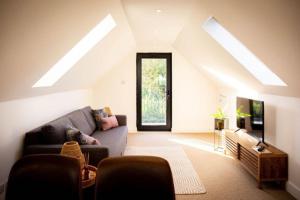 a living room with a couch and a tv at Doeling Barcombe in Isfield