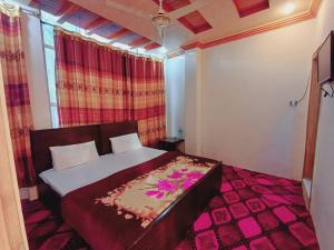 a bedroom with a bed with flowers on it at Stay Inn Hotel in Mingāora