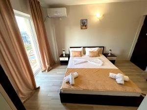 1 dormitorio con 1 cama con toallas en Pensiunea Regalux, en Eforie Nord