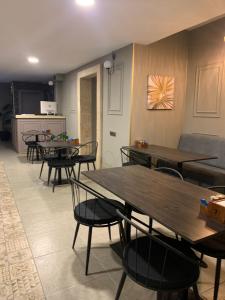 een eetkamer met tafels en stoelen en een keuken bij akcayzeytin otel in Akcay