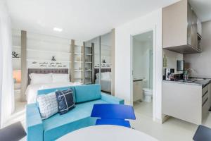 um quarto com uma cama e um sofá azul em BHomy Brooklin Moderno e com vista linda GB132B em São Paulo