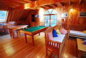a room with a pool table in a cabin at Terra Luna Lodge in Puerto Guadal