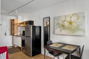 cocina con mesa y nevera negra en Studios On 25th by BCA Furnished Apartments, en Atlanta