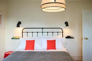 sypialnia z łóżkiem z 2 czerwonymi poduszkami w obiekcie Modja Modja House w mieście Kent